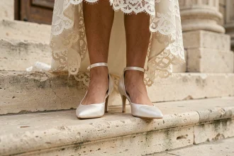 Chaussures de mariage blanches en satin avec bride cheville et perles sur marches en pierre